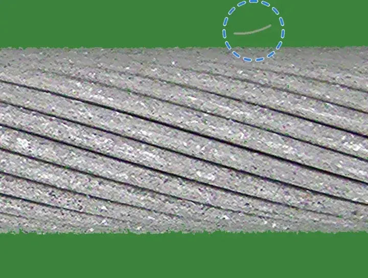 Healthy training crop with a thin light fibre lying on the green background above the cable, not touching it, ringed in dashed blue.